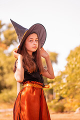 Girl 11 years old against the background of autumn nature. Little girl in Halloween costume, autumn.