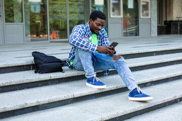 The pensive student sits in front of the university building