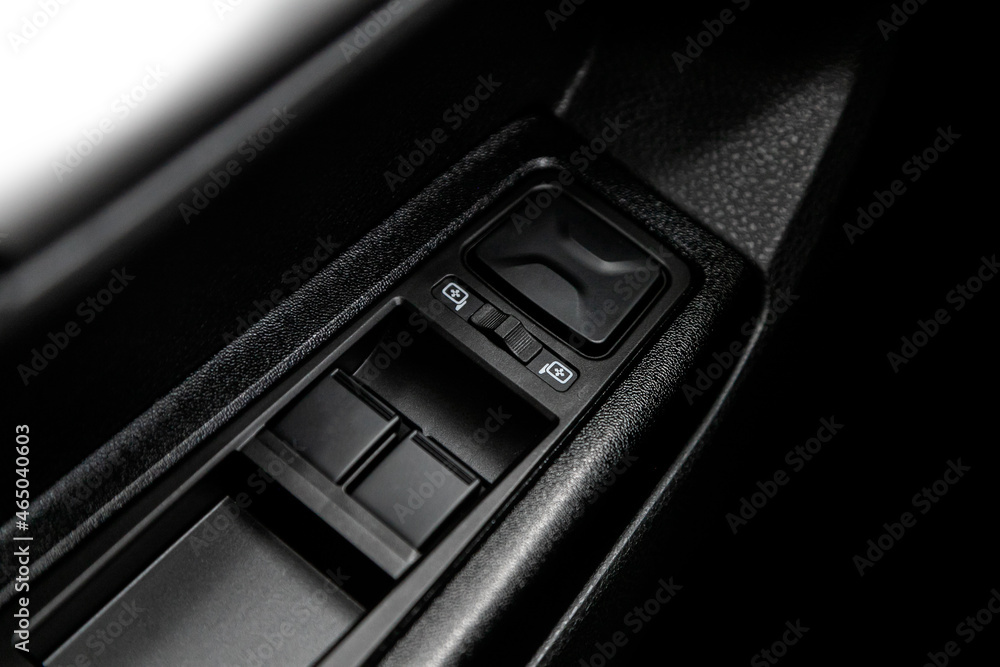 Poster closeup of a door control panel in a new car. arm rest with window control panel, door lock button, 