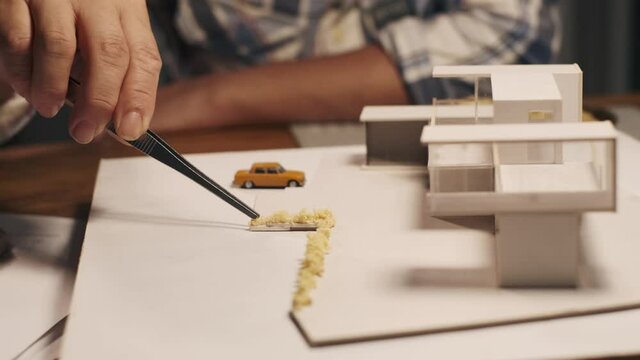 Selective focus hand of architect design making house modelling at his workplace. Model of modern house building. 
