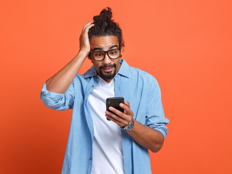 Shocked Surprised Young African American Man Looking At Smartphone With Stunned Face Expression