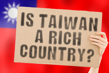 The question " Is Taiwan a rich country? " on a banner in men's hand. Money. Finance. Currency. Rate. Economy. Wealth. Salary. GDP. Million. Inequality. Economic. Income