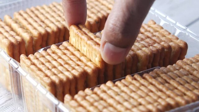  hand pick a whole wheat cracker on table ,