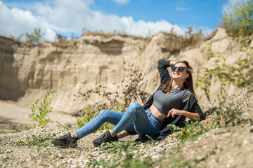 Naklejka na ściany i meble portrait of pretty young woman at nature. summer trip to sand quarry