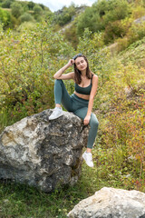 Naklejka na ściany i meble beautiful model girl posing near rocks in sand quarry or mountain