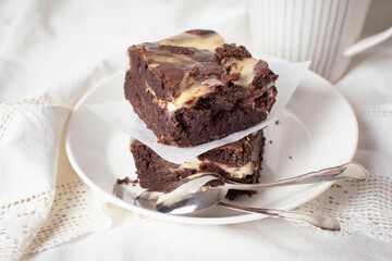 Stacked freshly baked marbled chocolate brownies on a plate