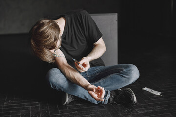 Drug addict injecting heroin into arm