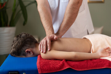 Obraz na płótnie Canvas Wellness massage for children. Hands of the masseur close-up. Physiotherapist working with patient in clinic