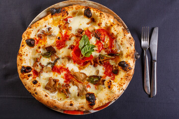 Pizza Napoletana con mozzarella, funghi e salame piccante fotografata dall'alto