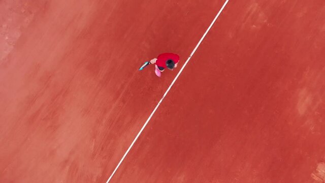 Top view of a man serving a ball while playing tennis