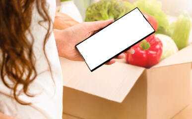 woman holds phone in hand with copy space. home delivery, grocery ordering, order collection