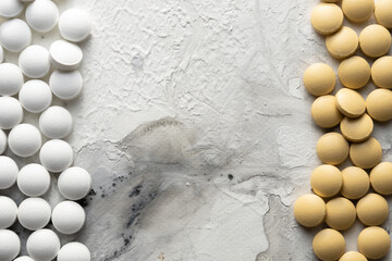 A handful of pills scattered on the table. A vial of medicines. Marble surface. Medicines. Stop COVID.