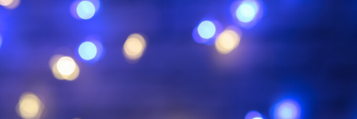 Banner made with the blurred lights of the garlands are blue and yellow. Light Blue bokeh background. Festive background. New Year's background.