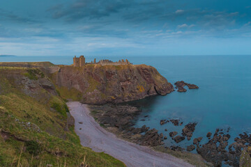 Fototapeta na wymiar Dunnottar Castle is a ruined medieval fortress located upon a rocky headland on the north-eastern coast of Scotland south of Stonehaven. Sunset Evening