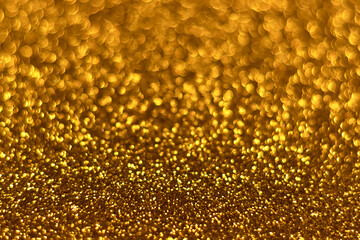 Golden sparkling glitter bokeh background, christmas abstract defocused texture. Holiday lights