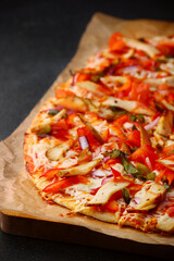 roman pizza with chicken vegetables and bbq sauce on dark concrete table