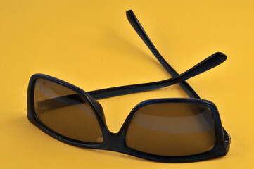 Lunettes de soleil en gros plan sur fond jaune
