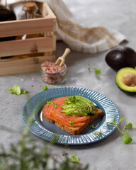 Breakfast toast with salmon, avocado and herbs 