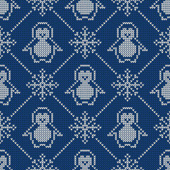 Knitted seamless pattern with penguins and snowflakes. Sweater background.