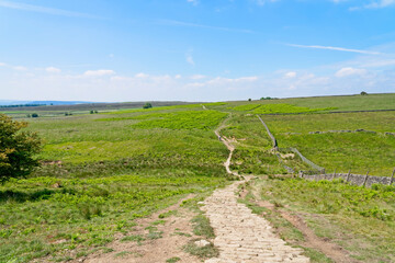 Cobbled path runs down a steep hill then winds across the Derbyshire moors