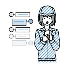 立ってスマートフォンで楽しくチャットで会話する作業員の女性