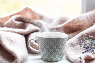 Cozy autumn composition with warm blanket, cup of hot tea and dry lavender bouquet. Hygge style composition.