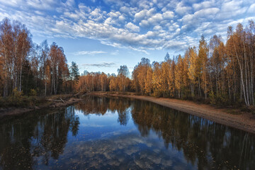 Beautiful river Renya in Tver region, Russia at sunset of the day. Beautiful reflection of clouds. Autumn photography. Blurred focus.