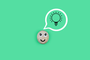 Character from a pebble with a happy face and a burning light bulb in his mind. Сharacter from the pebble found a solution