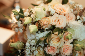 two golden wedding rings on a bouquet