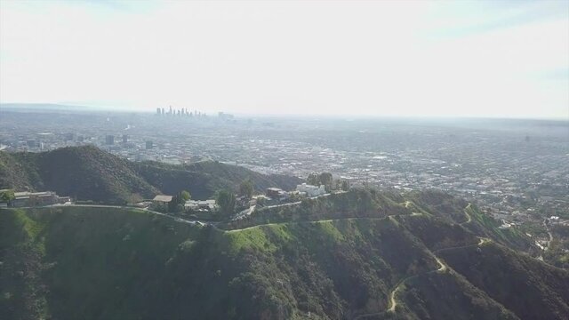 Aerial view overlooking the Hollywood Hills, with Los Angeles downtown background - circling, drone shot