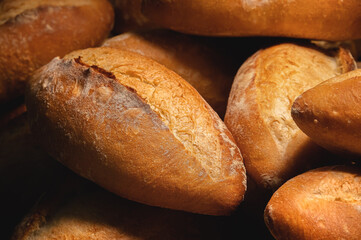 Close-up of sourdough bread. Freshly baked bread with a golden crust on the wooden shelves of the bakery. The context of a German artisan bakery with an assortment of rustic breads.