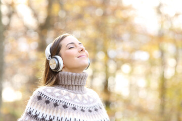 Woman listening to music and breathing in autumn