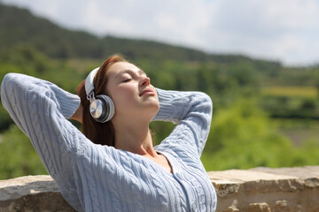 Fototapeta premium Woman relaxing outdoors listening to music