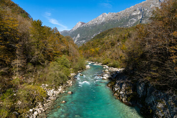 beautiful autumn color landscape in the Julian Alps of Slovenia with the clear turquoise Soca river in the foreground