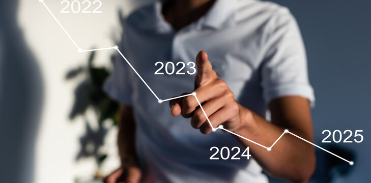 Finger pressing blue start 2023 button on virtual interface on gray background with copy space for text. Concept of new year. Businessman pressing 2023 start up business. Beginning of New Year 2023