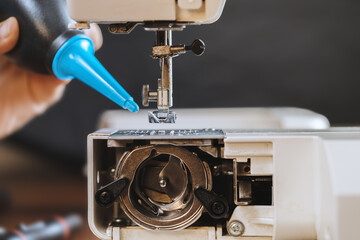 A young woman cleaning a sewing machine.
