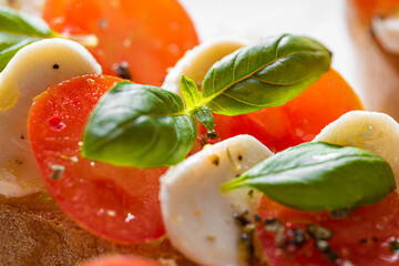 bruschetta caprese. fresh basil leaves, ripe aromatic tomatoes and Italian mozzarella on bruschetta, drizzled with olive oil and sprinkled with pepper and herbs.