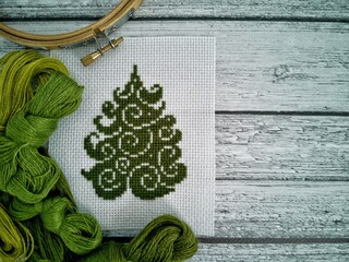 Christmas cross-stitch embroidery with christmas tree and woolen threads