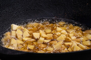 street food. fried potatoes. the process of cooking fried potatoes. potatoes are fried in a huge frying panstreet food