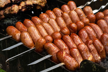 Sausages are roasted on the grill in the open air. Sausages are traditionally prepared at all gastronomic festivals. Very hearty and tasty dish. Street picture of food