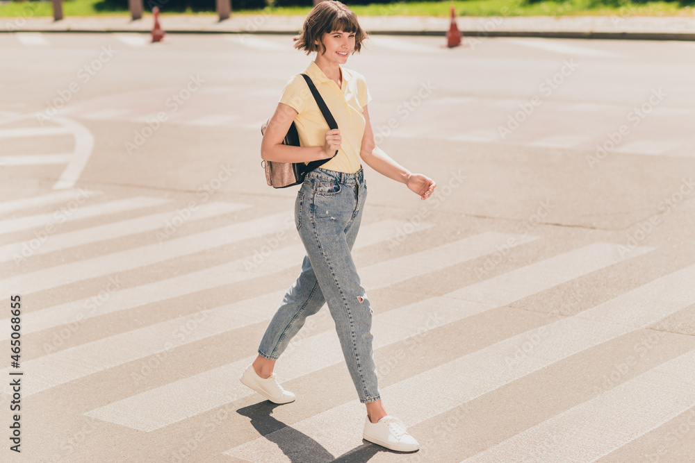 Wall mural Full size photo of nice young brunette lady go wear t-shirt jeans sneakers outside in park