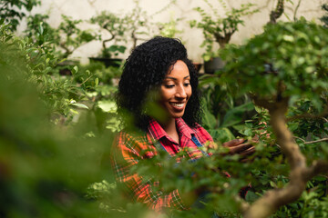 Naklejka premium careful woman taking care of plants in the garden
