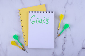 Target and goal concept with arrows and notebook