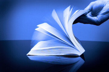 Book and Hand Flipping Pages Information Reading