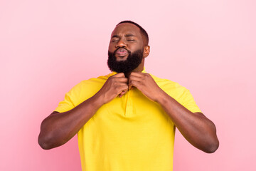 Obraz premium Portrait of attractive metrosexual dreamy guy fixing collar isolated over pink pastel color background