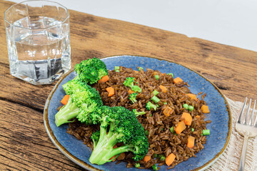 Fried rice with broccoli carrot bean on wood table.
