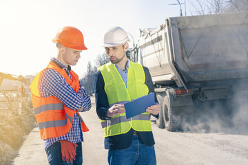 Two Surveyors Inspect Building Construction Site. Group of construction engineers on a building plot.