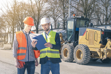 Surveyor and equipment at construction site. Excavator and Construction Equipnent on background.