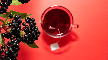 Top A mug of red tea. Natural herbal tea, a medicinal drink made from black elderberry berries