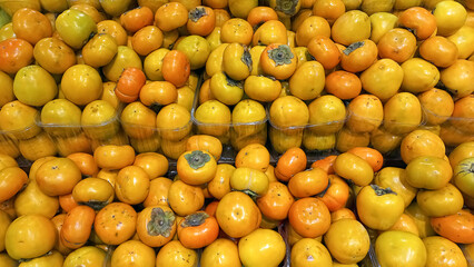 Persimmon fruits. Fresh subtropical fruits for sale on farmers market